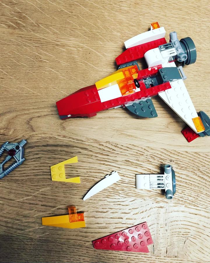 Il jet costruito con mattoncini LEGO sfusi, con accanto i pezzi provati e scartati